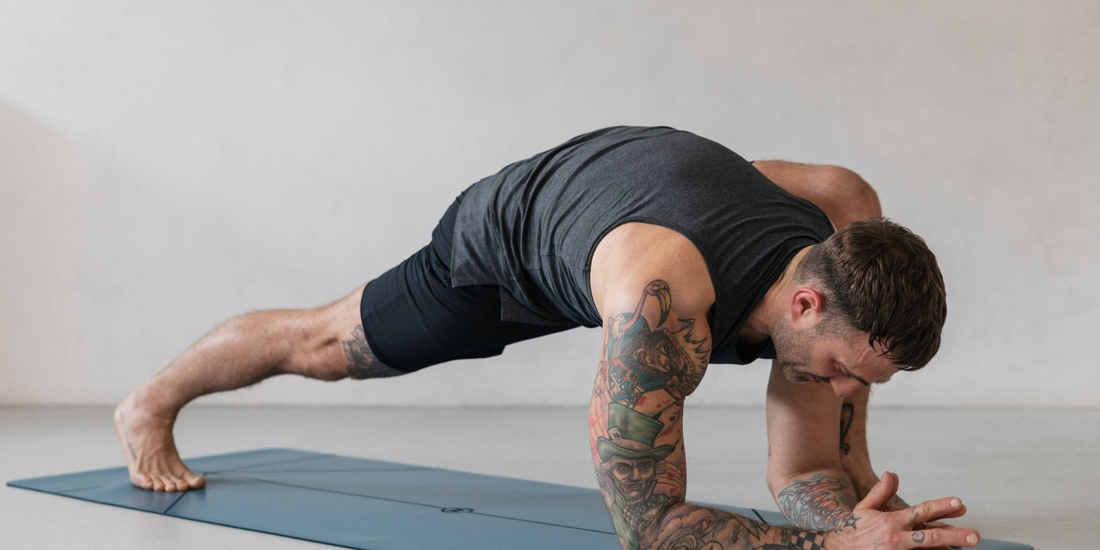 man doing yoga on a blue warrior addict mat