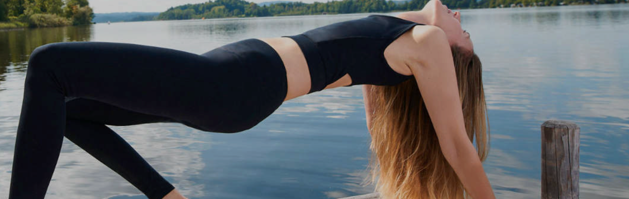 model in blue yoga pants with pockets doinng yoga in front of a building