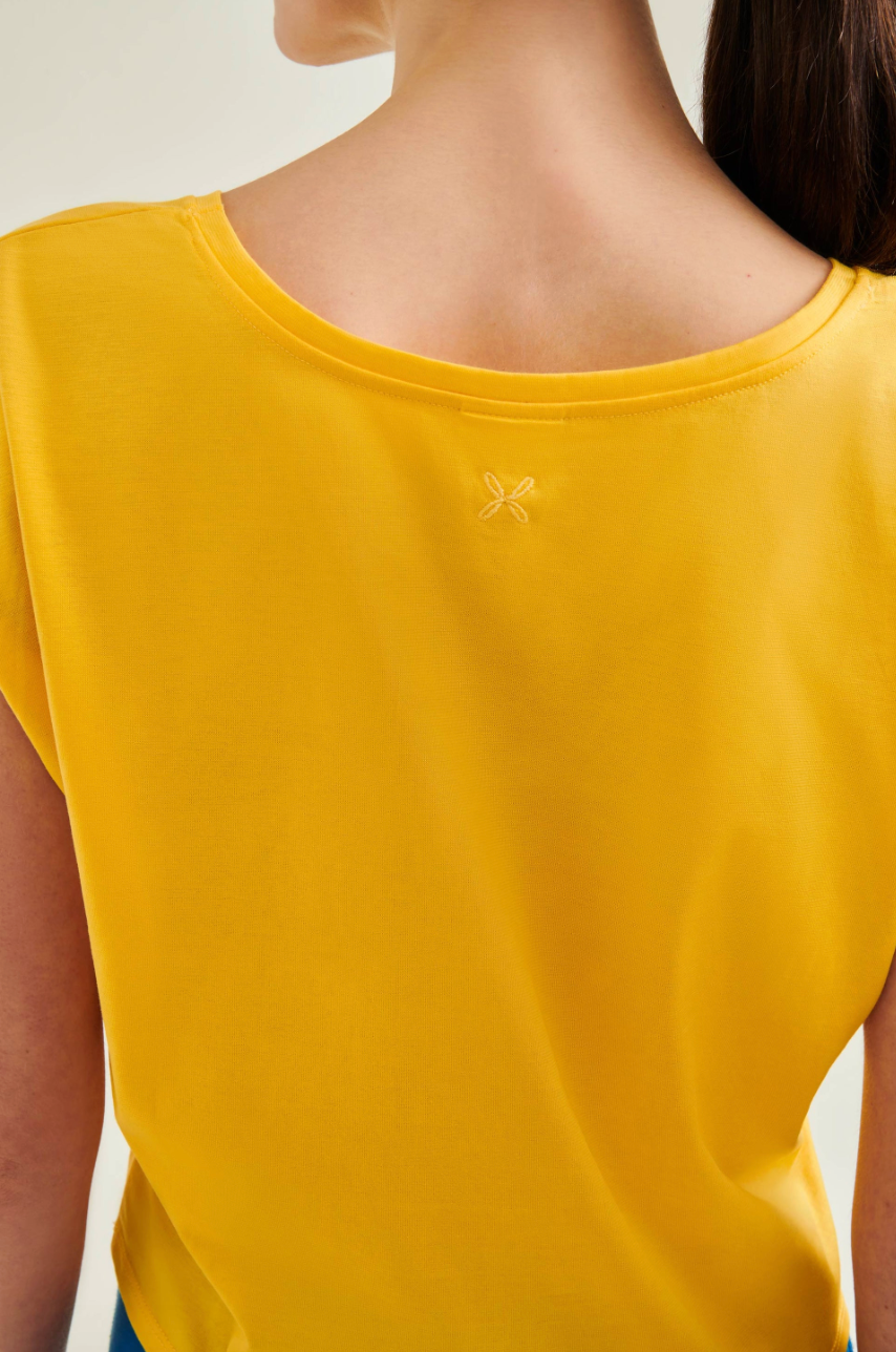 Yellow t-shirt with a brand logo on a plain background