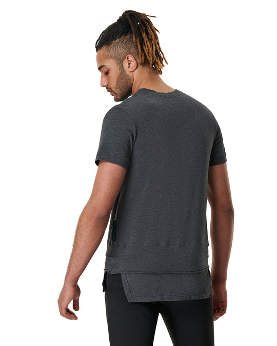 Man facing away wearing a heather grey t-shirt and black pants.