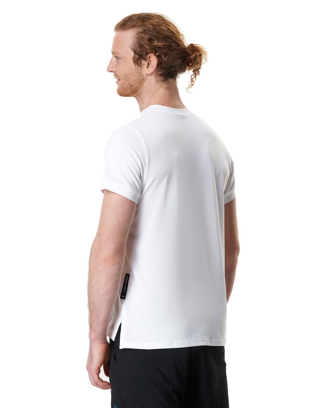 Man in white t-shirt, black shorts, looking left.