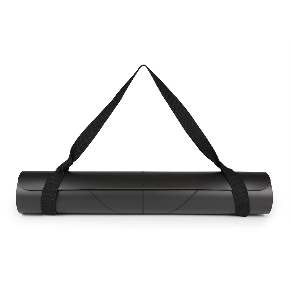 Rolled black yoga mat with black carrying straps on a white background.