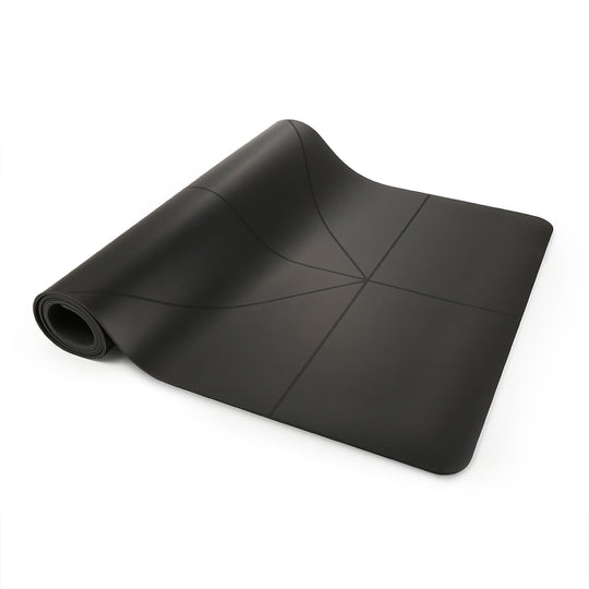 Black yoga mat, partially rolled with alignment lines.