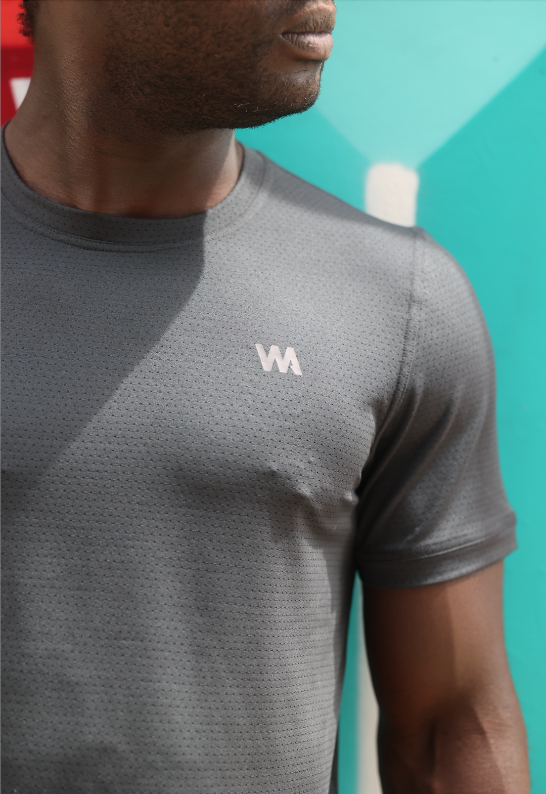 Man wearing a black Men's Warrior Skin T-shirt with a Warrior Addict logo on it against a blue background