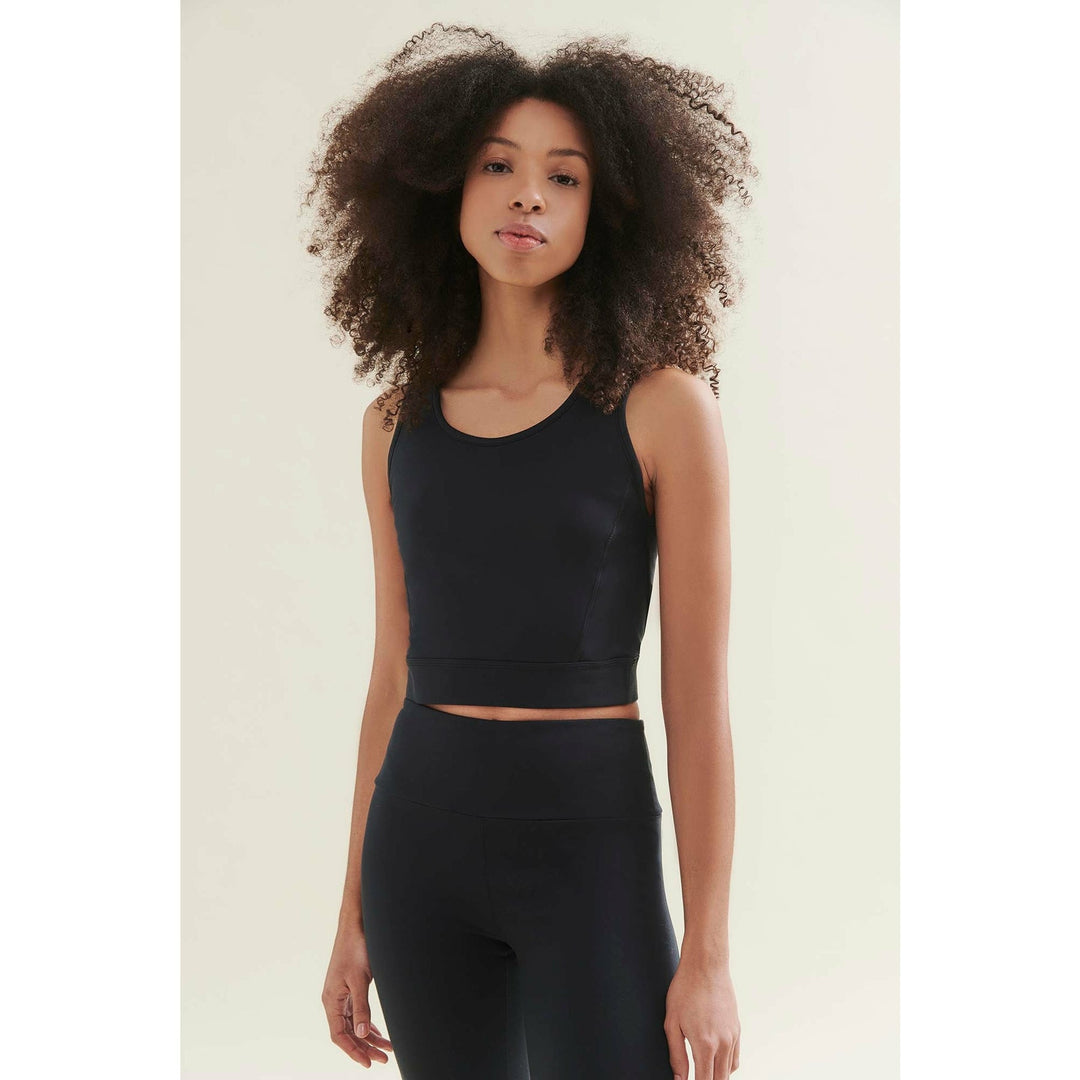 Woman in black athletic crop top and leggings.