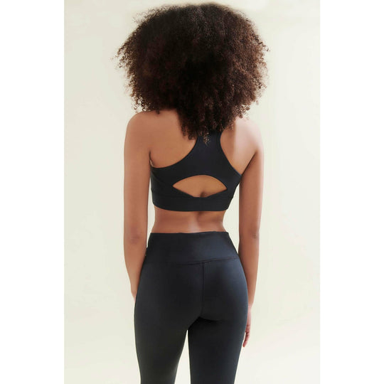Woman wearing black athletic wear, back view.