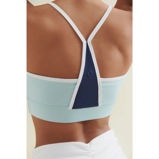 Close-up of the back of a light blue and navy sports bra with white straps.