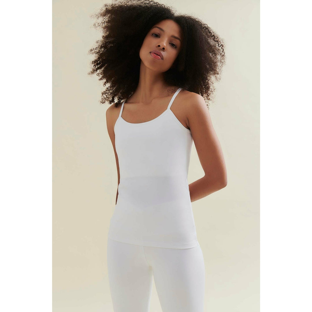 Woman in white tank top and leggings.