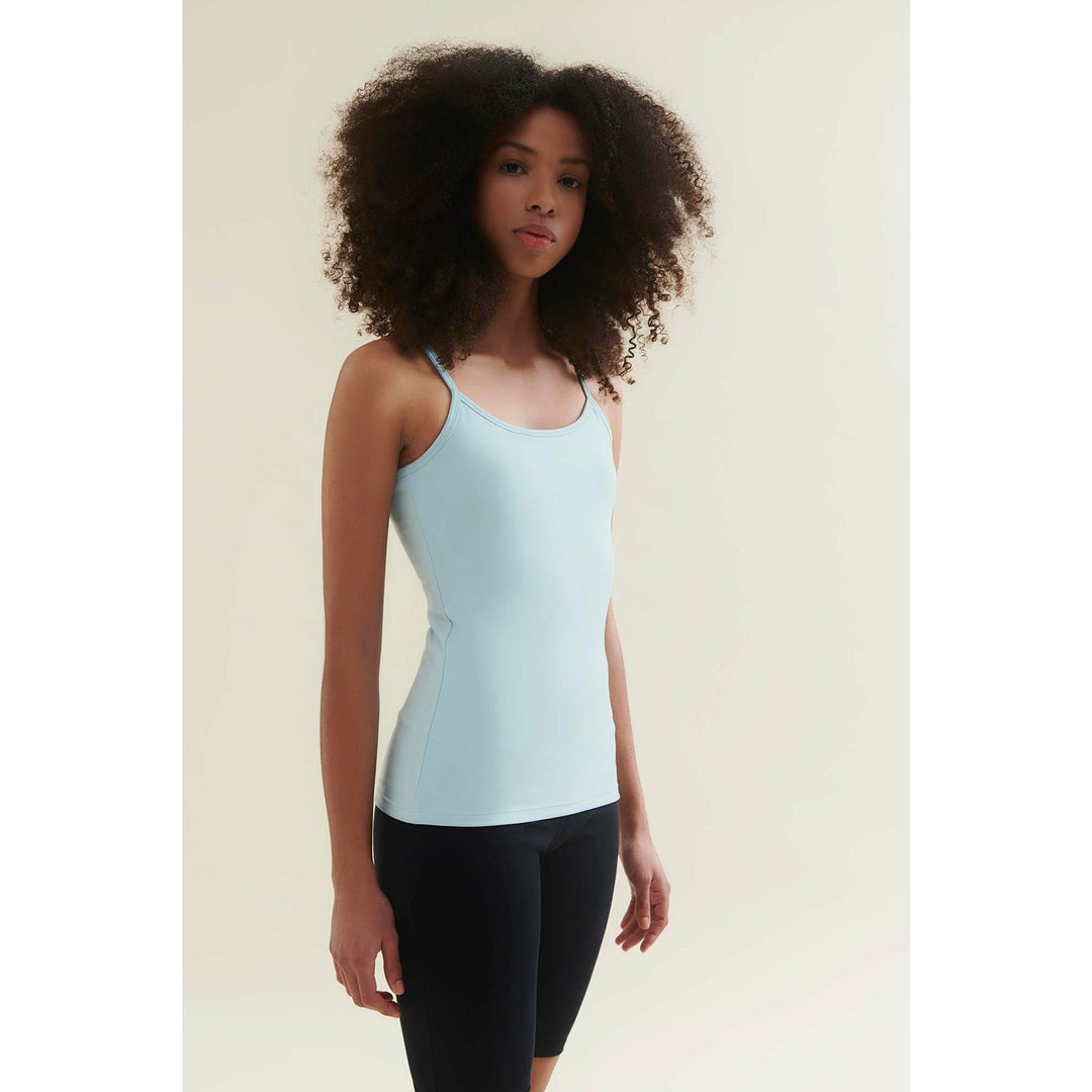 Woman wearing a light blue camisole and black leggings.