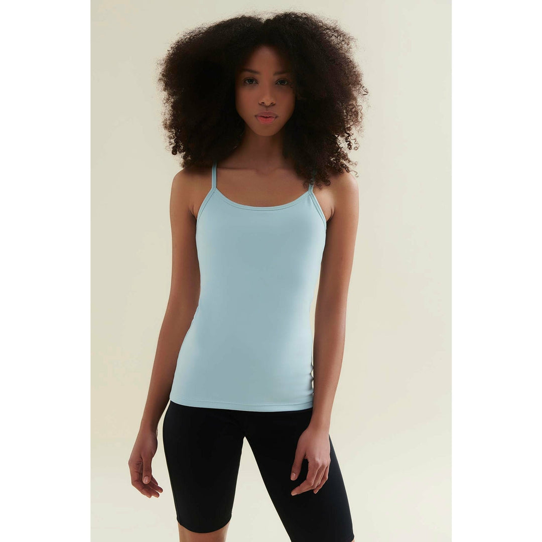 Woman in a light blue camisole and black bike shorts.
