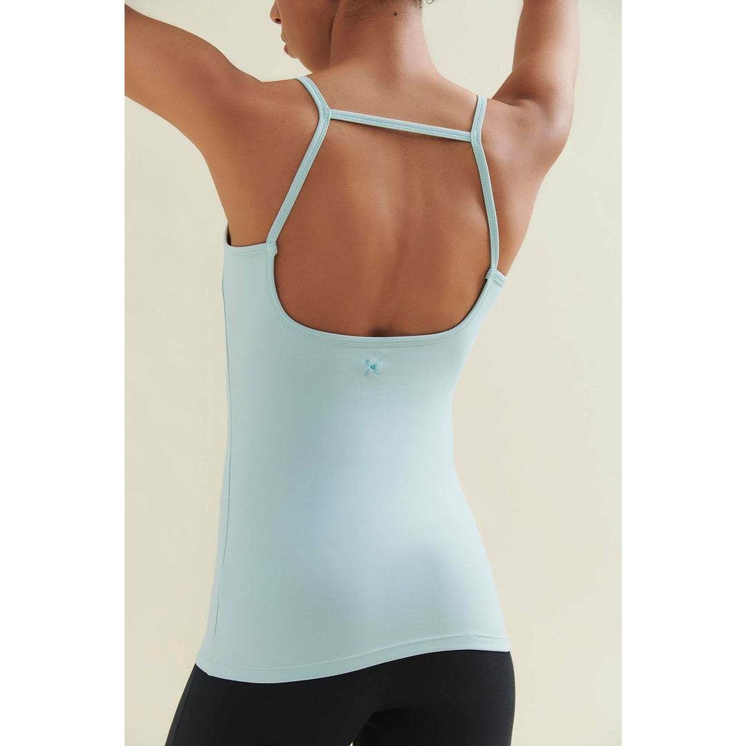 Woman in light blue tank top and black leggings from behind.