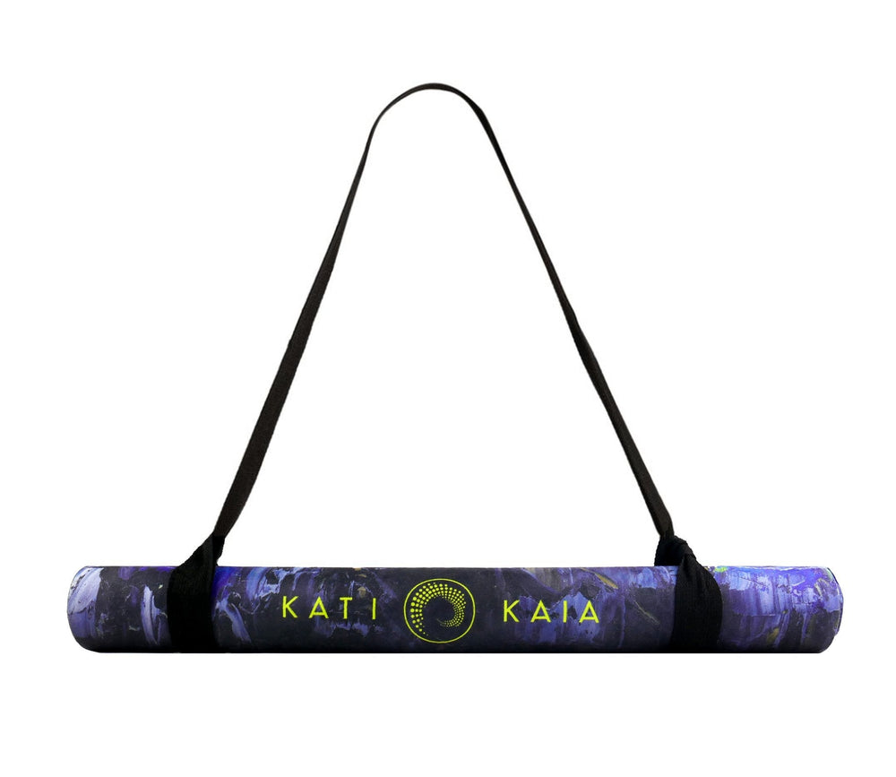 Rolled purple yoga mat with a black carrying strap.