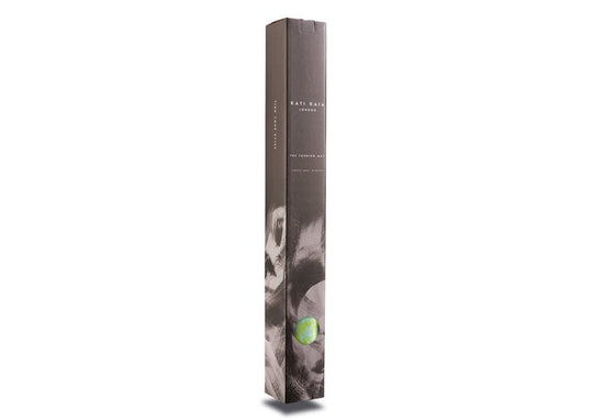 Tall, narrow, gray box with a gray brushstroke pattern. "KATI KAIA LONDON" and "THE TOURING MAT" are printed vertically on the box. A blue and green marble is attached to the box.
