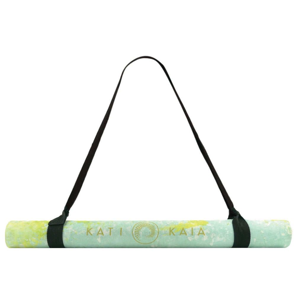 Rolled yoga mat with black strap.