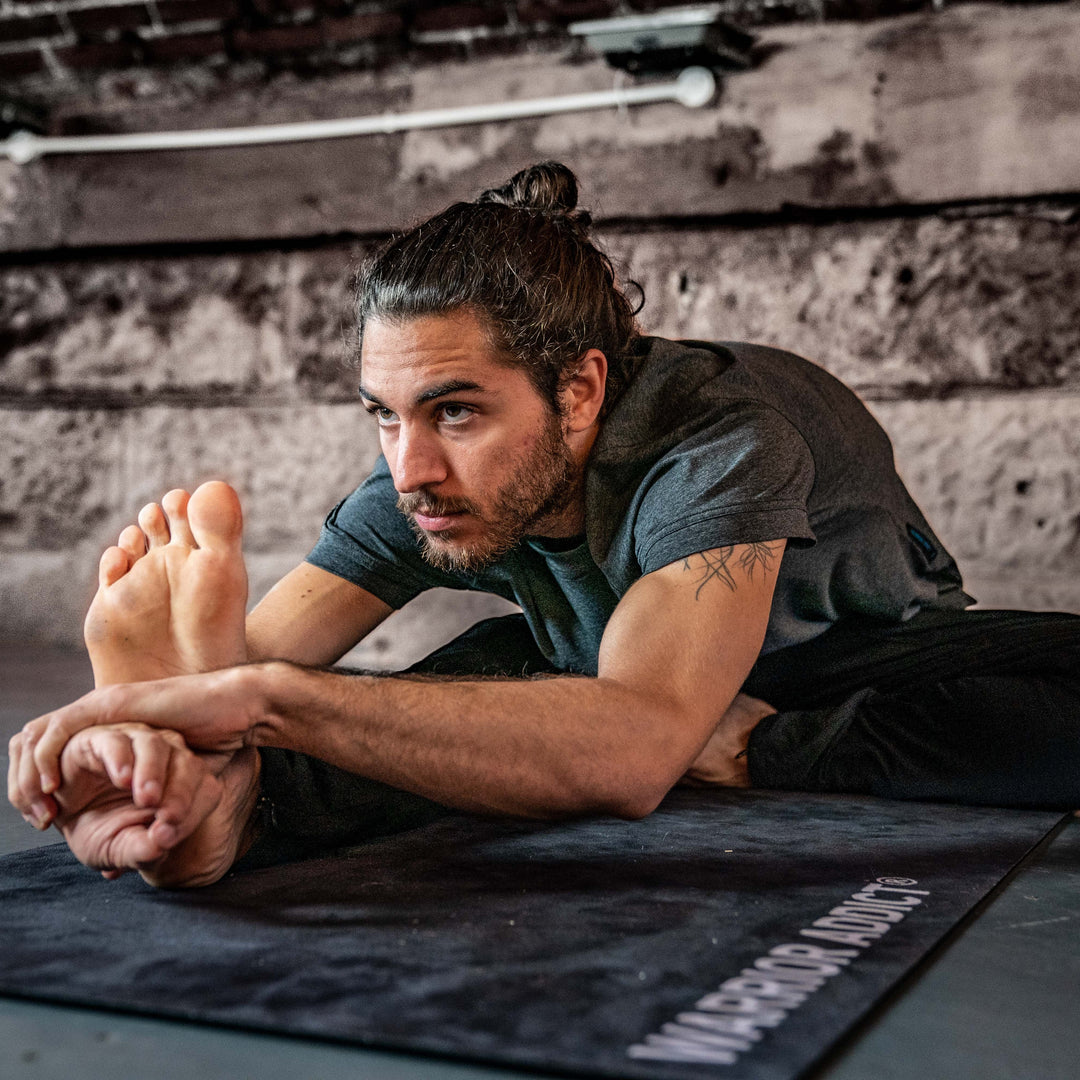 man doing yoga on a warrior addict mat 