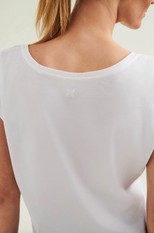 White sleeveless top worn by a person on a plain background