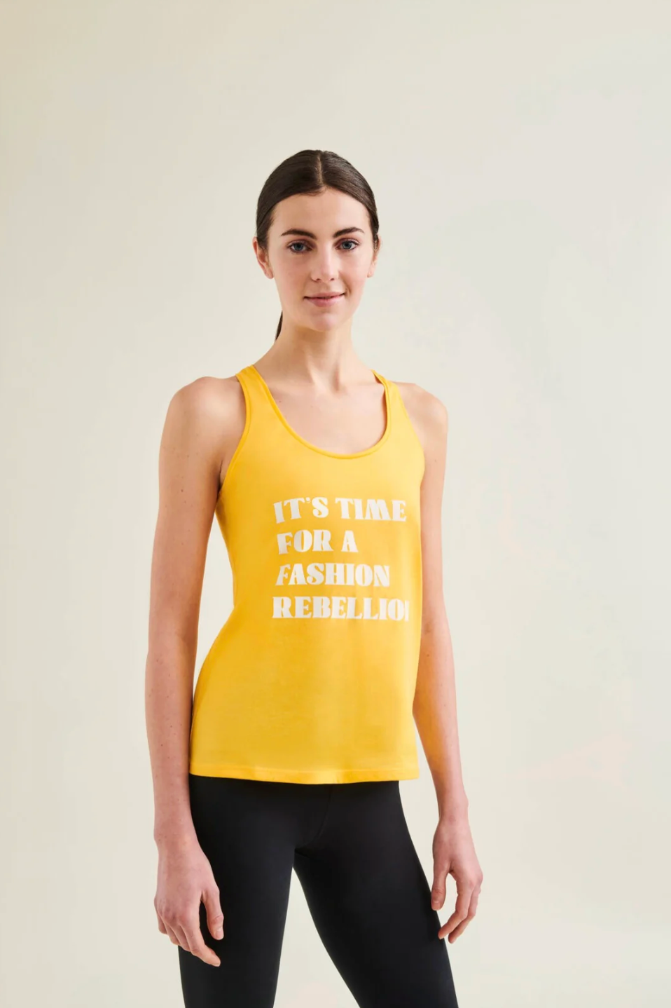 Woman wearing a yellow tank top with text on a plain background
