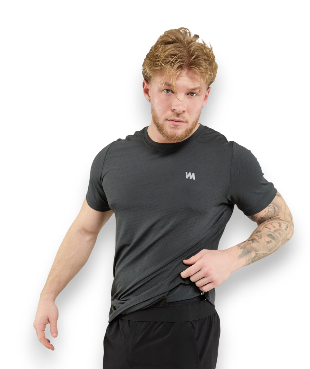 Man wearing a black t-shirt  no ride up  inversion tech t shirt with WA logo showing mechanism 
