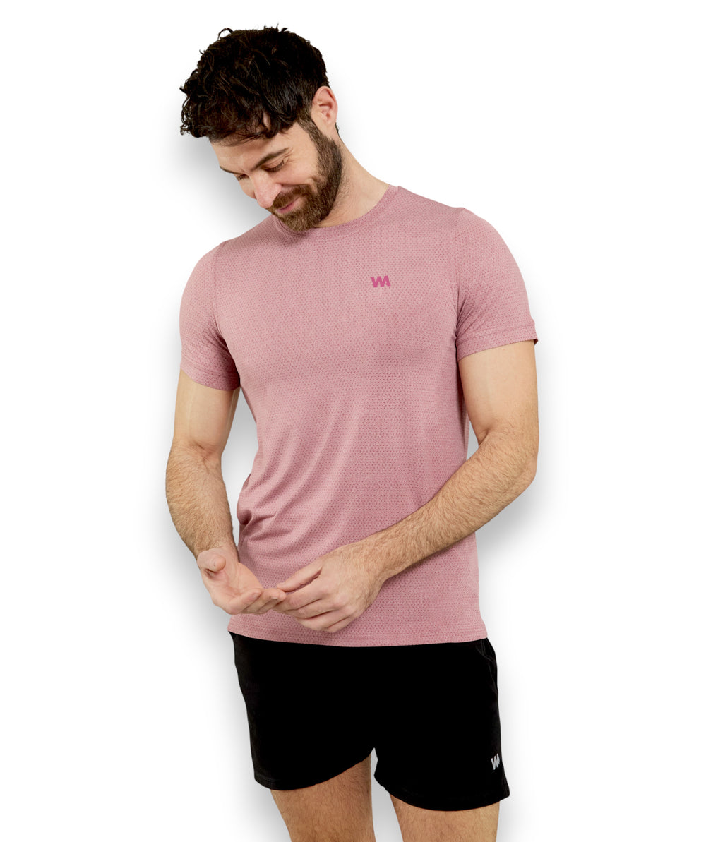 Man wearing a pink warrior addict training  t-shirt and black shorts on a white background