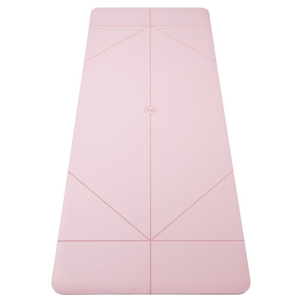 A light pink yoga mat with geometric line patterns and a small circular logo in the center, shown flat against a solid white background.
