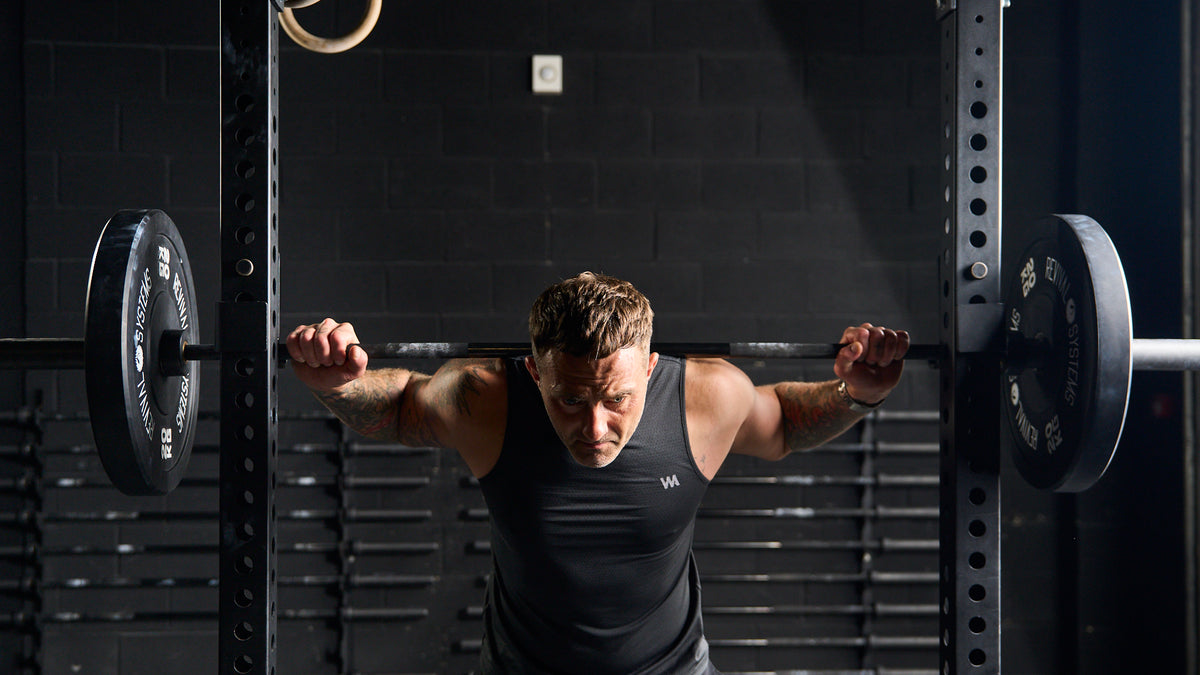 Man lifting a barbell in a gym setting