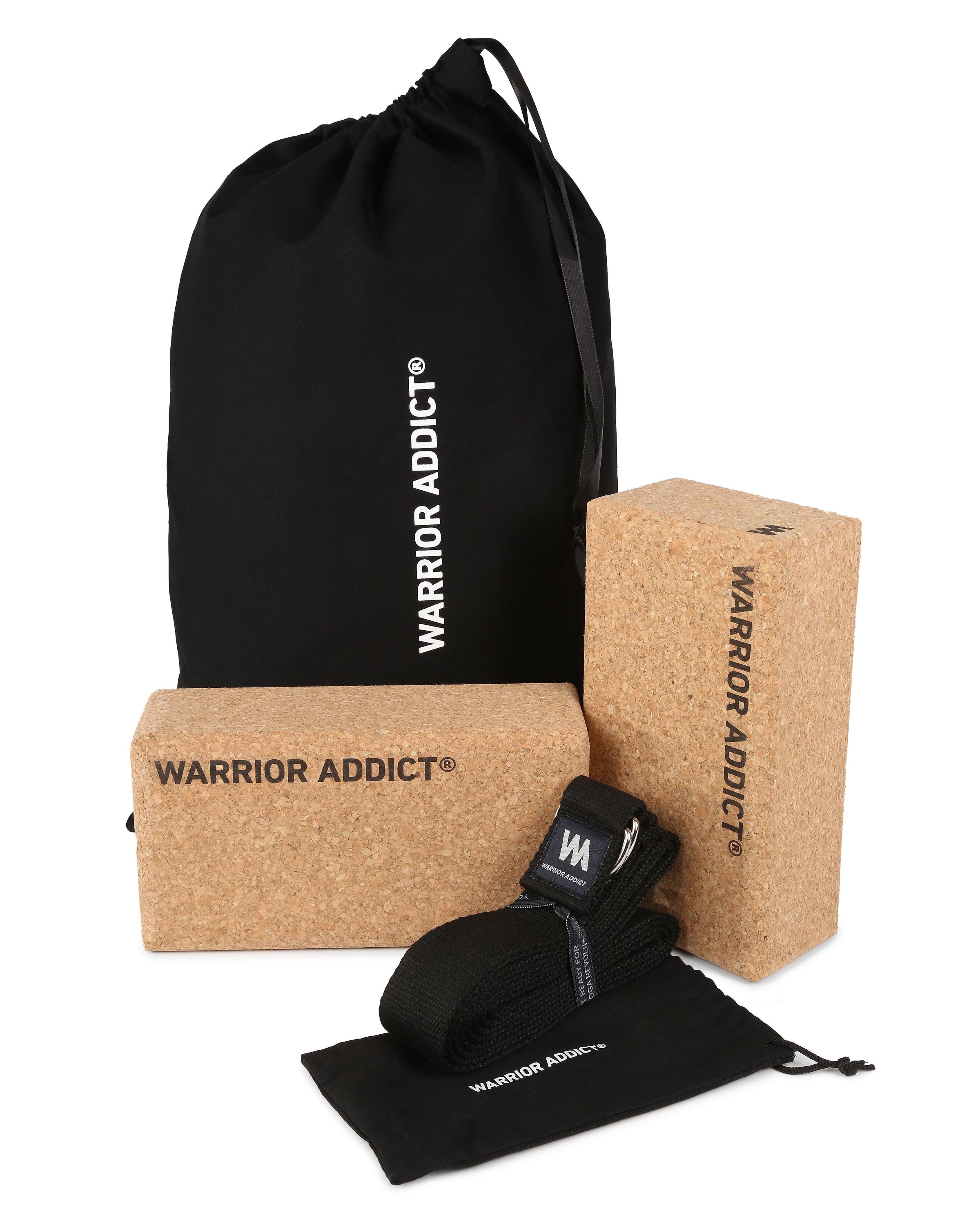Yoga equipment with cork blocks, a black strap, and drawstring bags, all branded with "Warrior Addict".