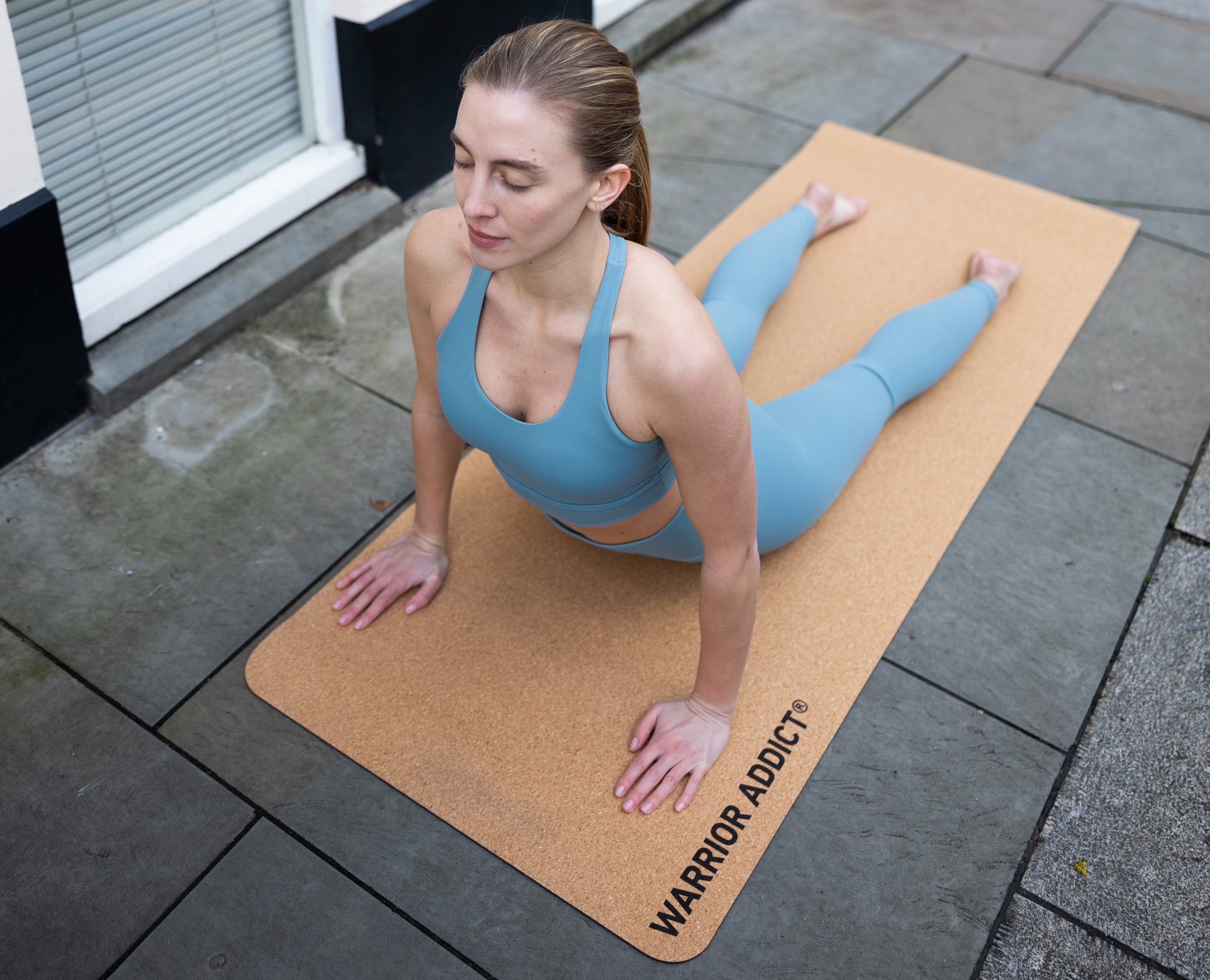 woman doing yoga on a cork yoga mat by warrior addict 