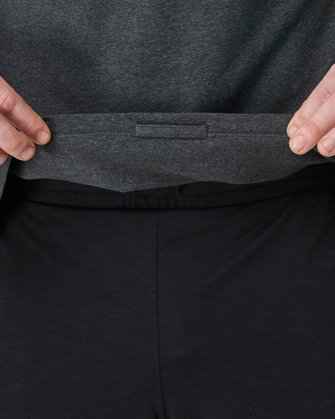 detil of a grey yoga top showing a hidden inside loop to tie too chords