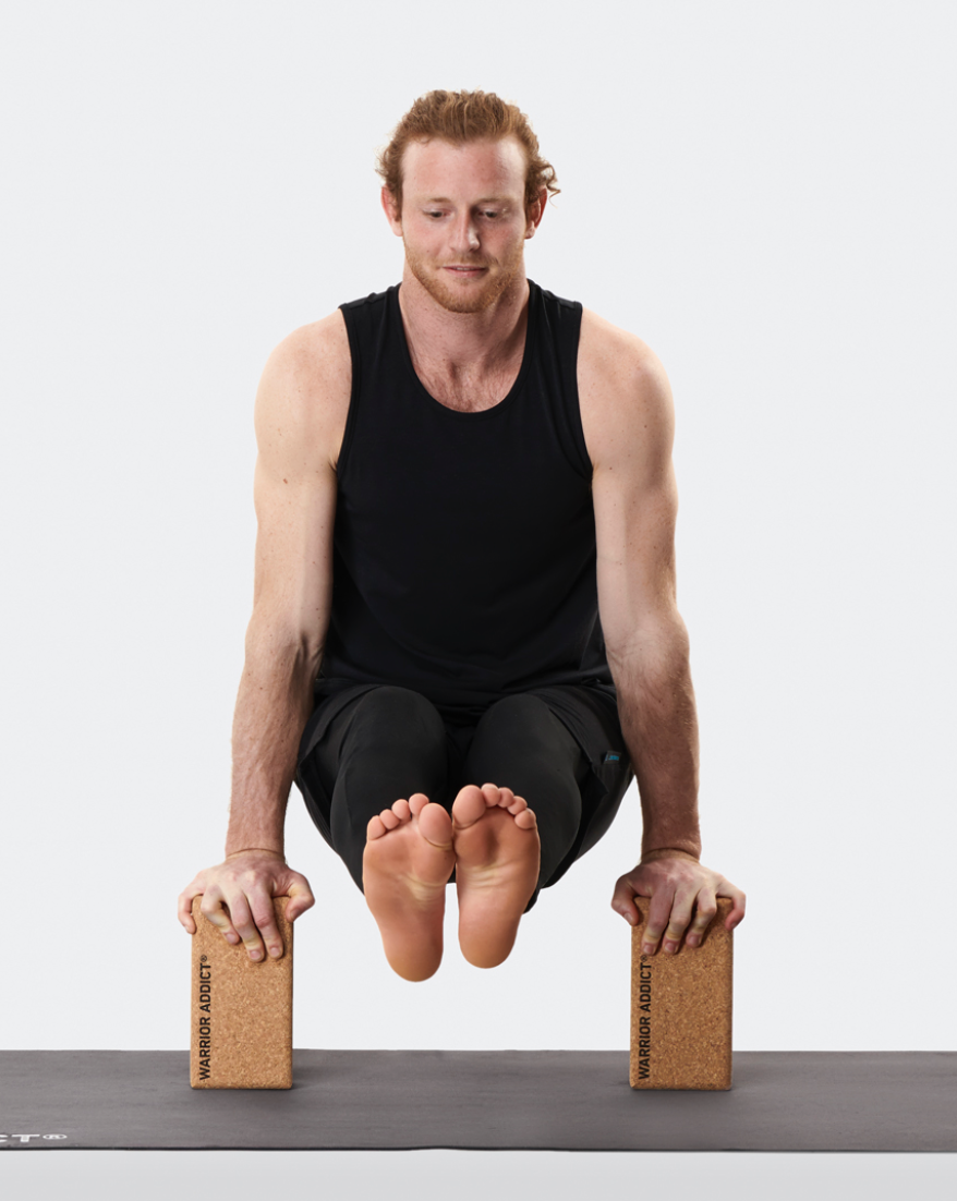 man balancing on two cork yoga blcoks 