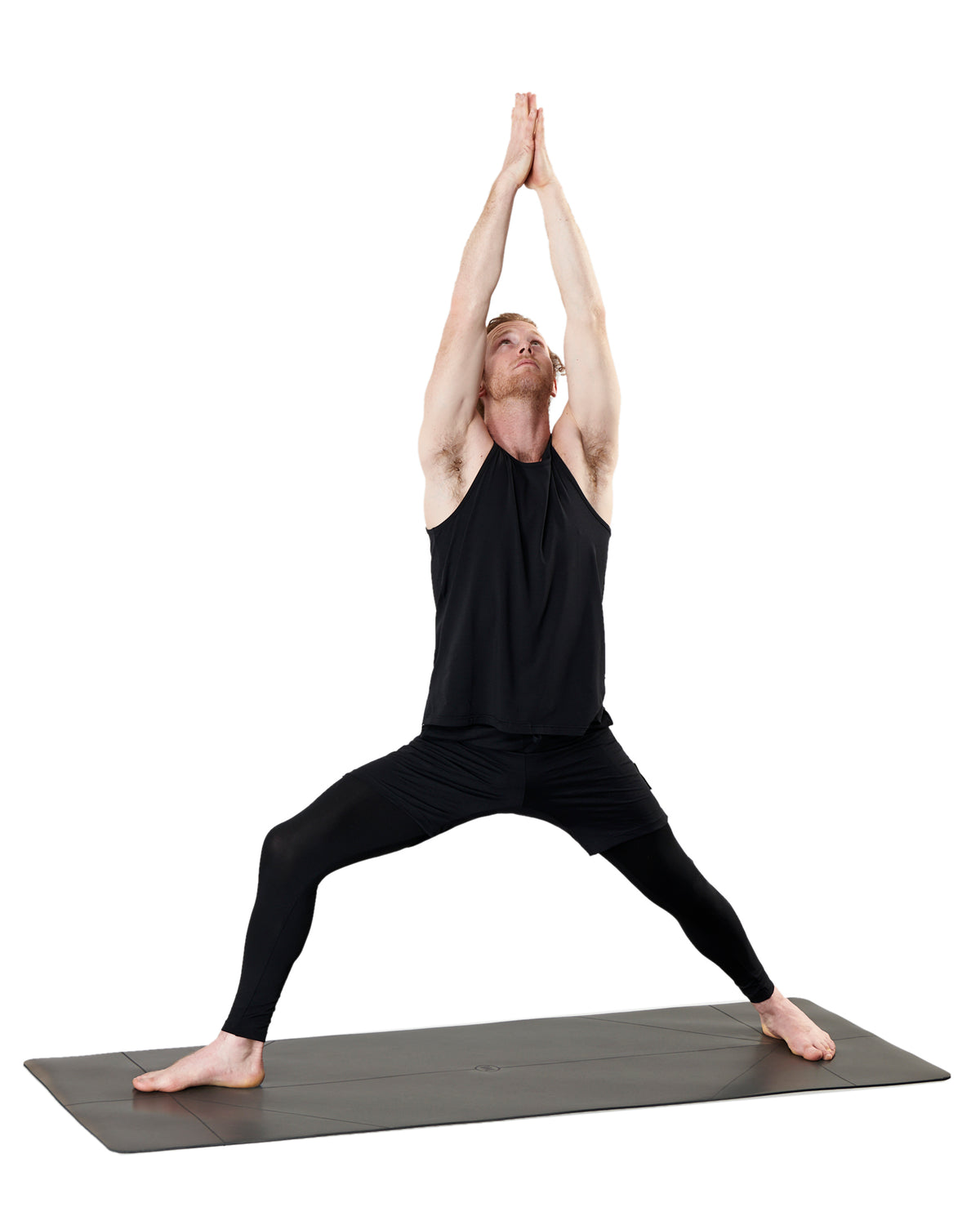 man practicing yoga on warrior addict yoga mat with guide lines 
