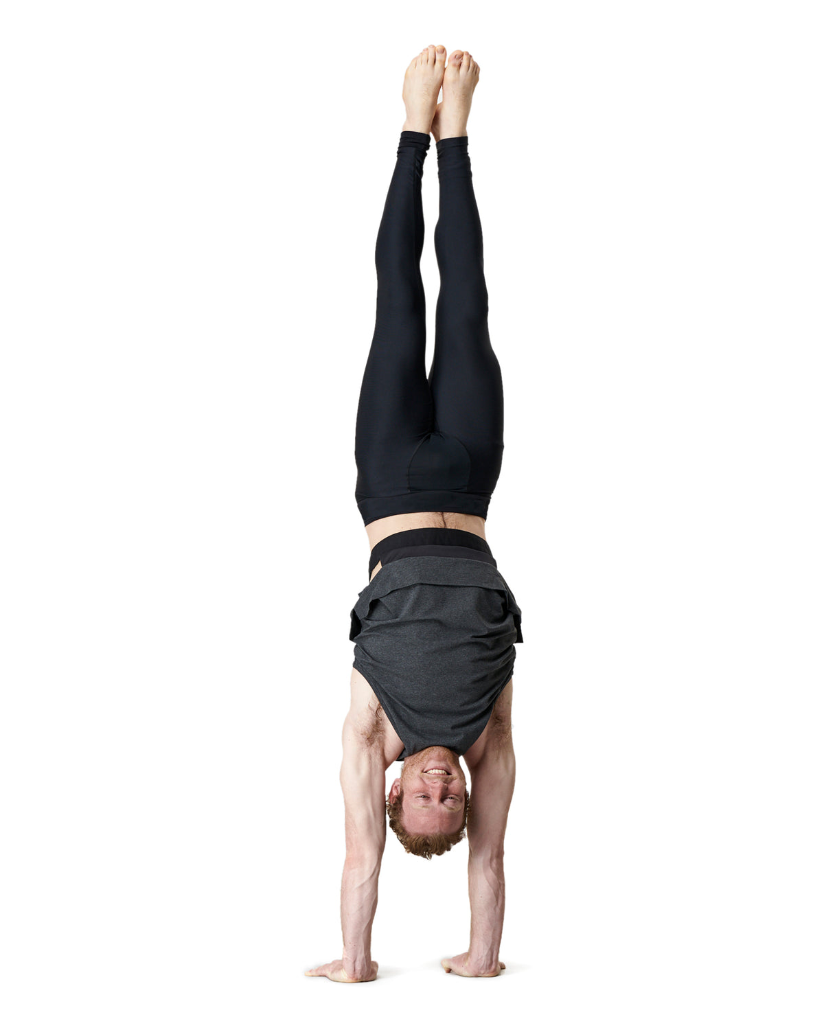 man doing a handstand in warrior addicts grey mens yoga top that does not ride up
