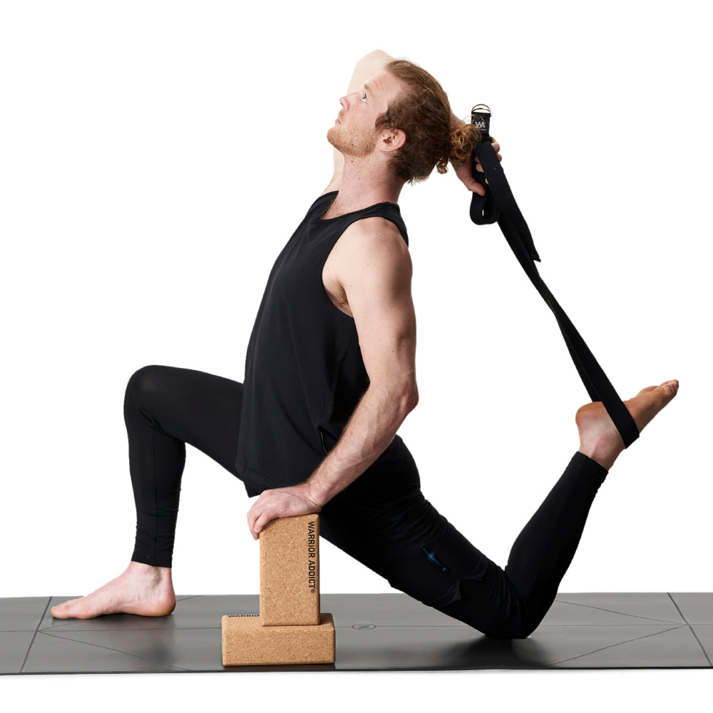 man doing yoga on warrior addict black mat with cork blocks and yoga strap