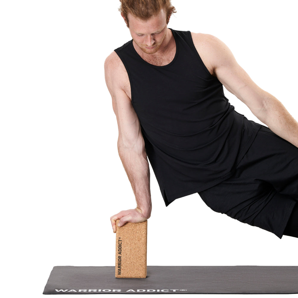 man balancing on cork yoga block and yoga mat by warrior addict 