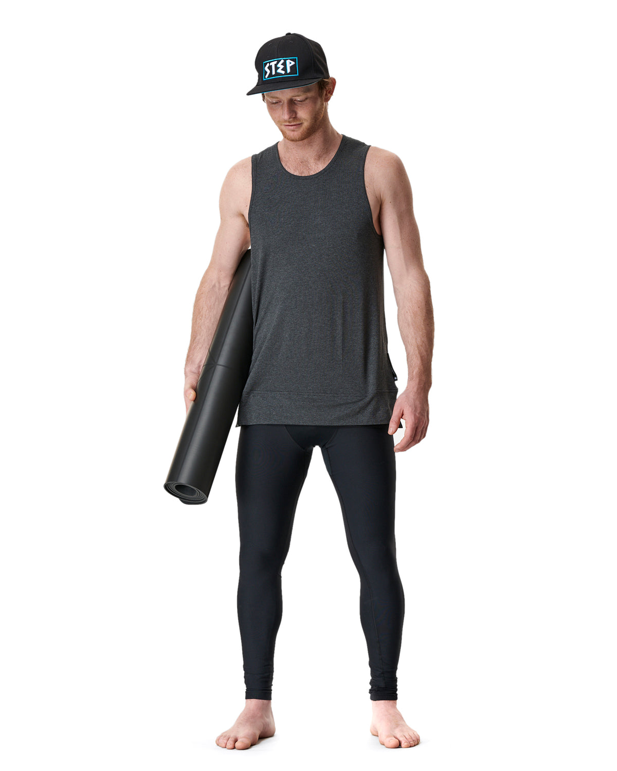 man wearing warrior addict yoga clothes carring a yoga mat 