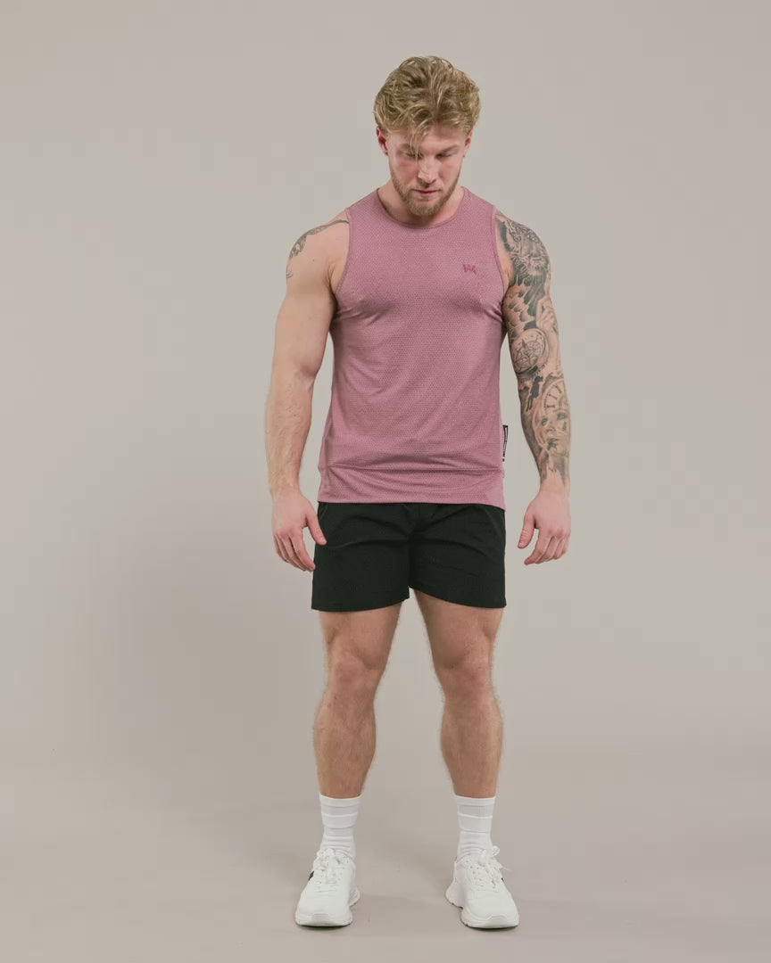 male model wearing pink warrior addict no ride up inversion tank and doing a back flip 