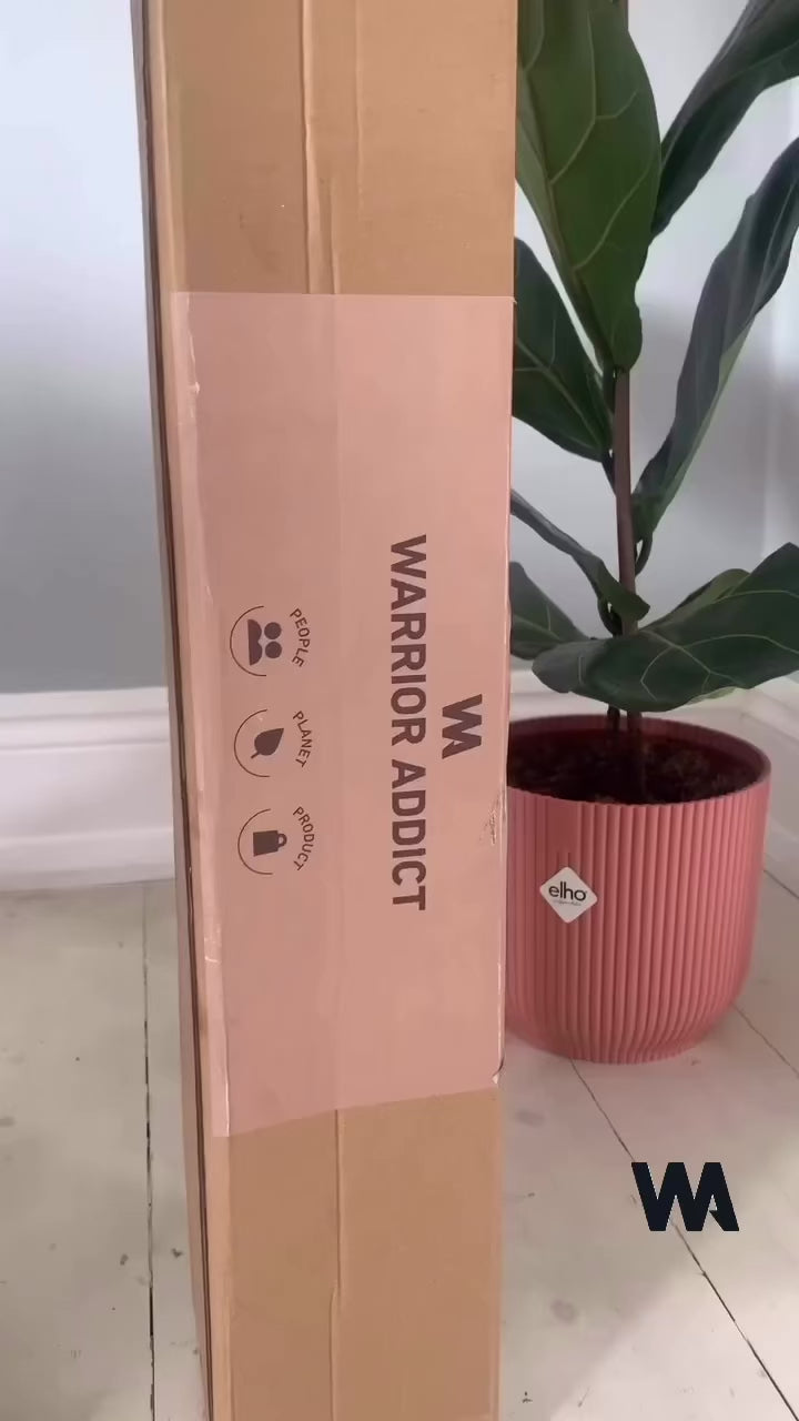 woman unrolling and practicing on a warrior addict blue yoga mat 