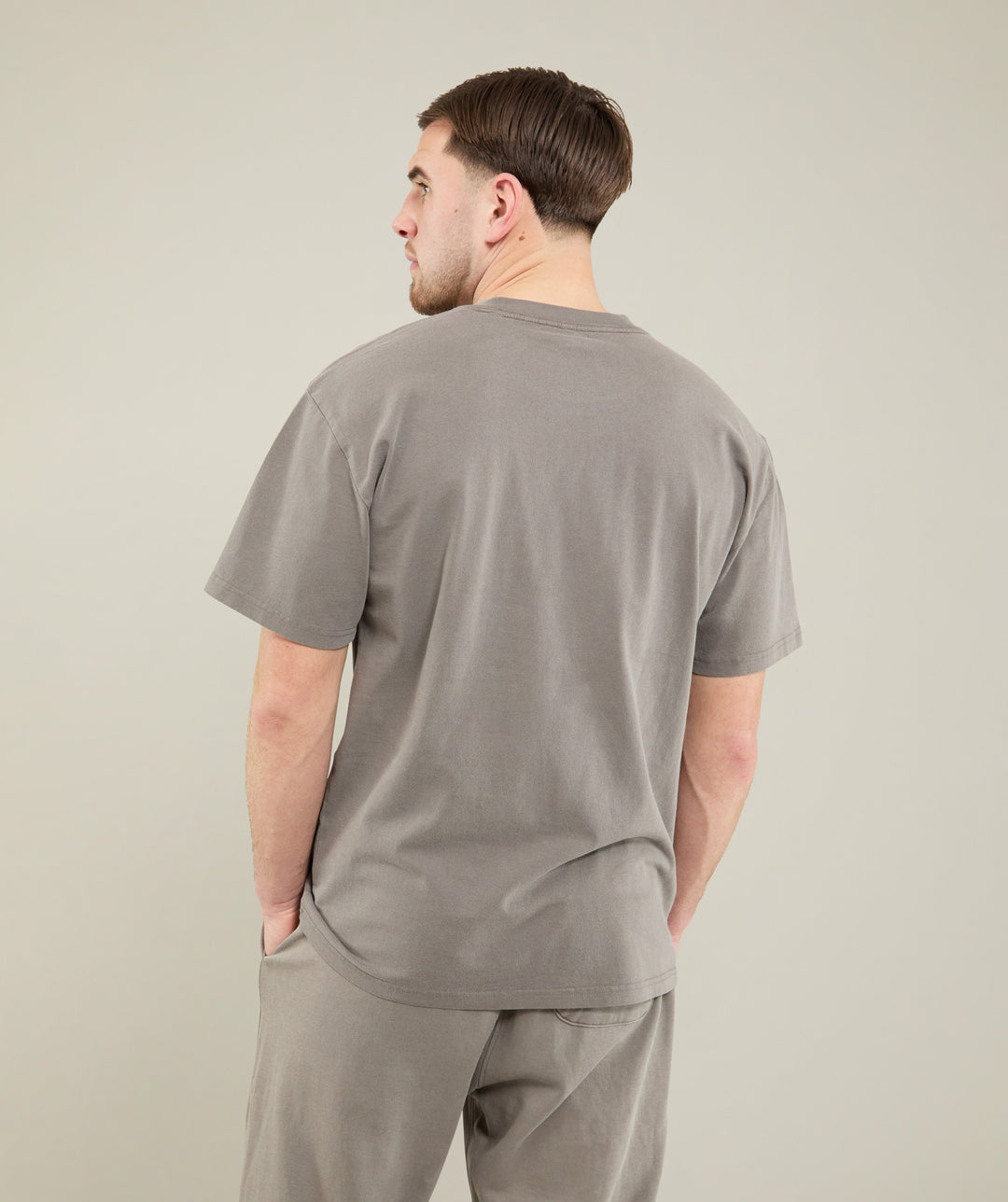 Man wearing a gray t-shirt on a plain background