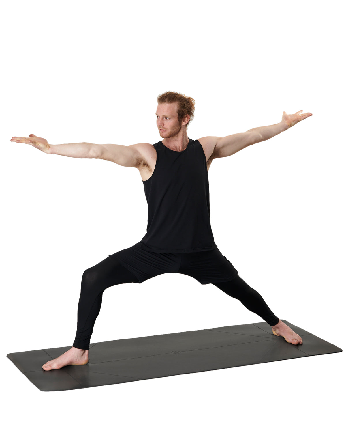 man doing a warrior pose on a black mens yoga mat by warrior addict
