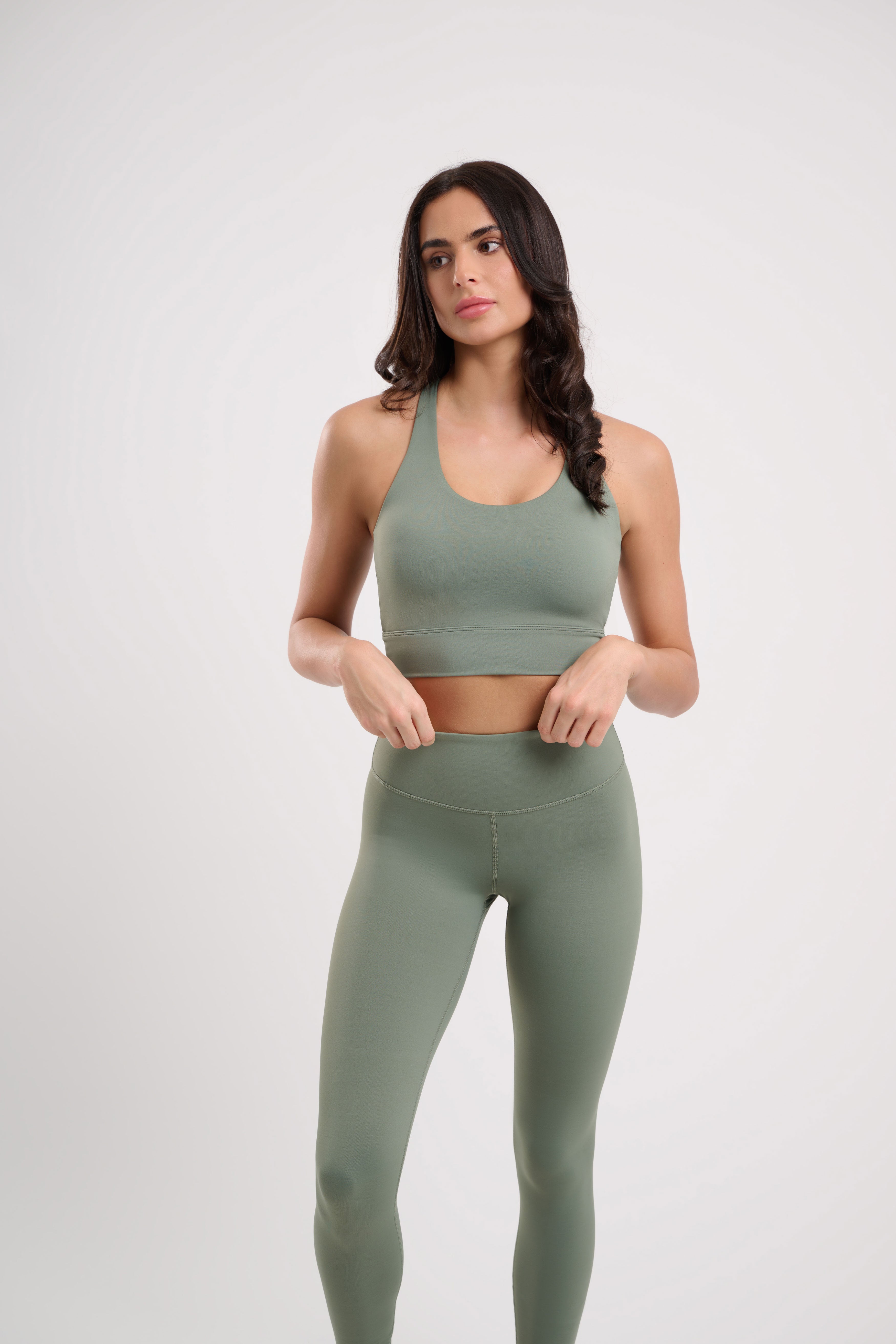 Woman in green sports bra and leggings.