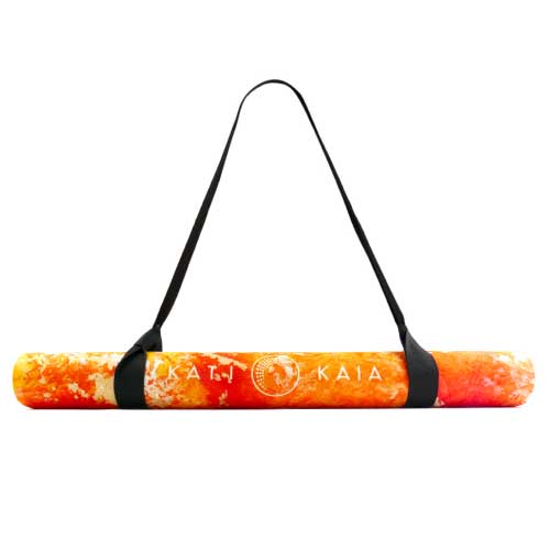 kati kaia travel yoga mat in orange rolled with carry strap 